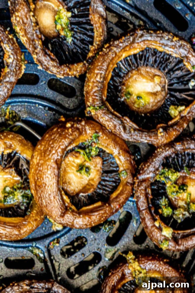 A close-up shot of a pan filled with beautifully air-fried mushrooms, showcasing their rich, browned texture.