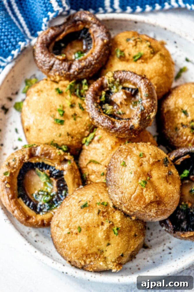 A serving of the Best Air Fried Mushrooms Recipe elegantly presented as a side dish on a pristine white plate.