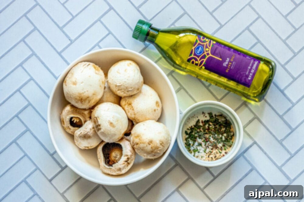 Ingredients for air-fried mushrooms laid out: fresh mushrooms, a bottle of olive oil, and a small bowl of herbs.