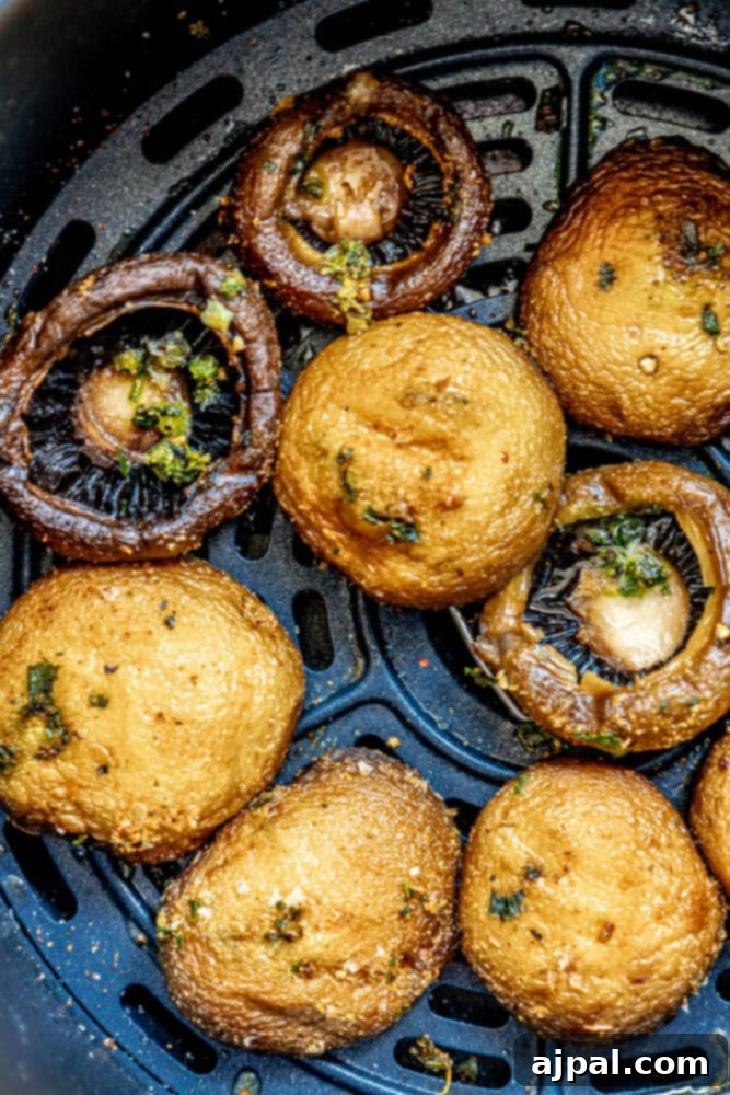 Air-fried mushrooms neatly arranged in the basket of an air fryer, showcasing their golden-brown color.
