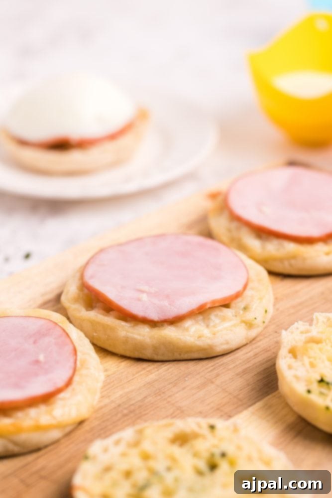 Toasted English muffins with Canadian bacon slices placed on top.