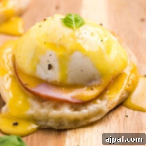 Easy Eggs Benedict recipe with ham and hollandaise sauce on a wooden cutting board.