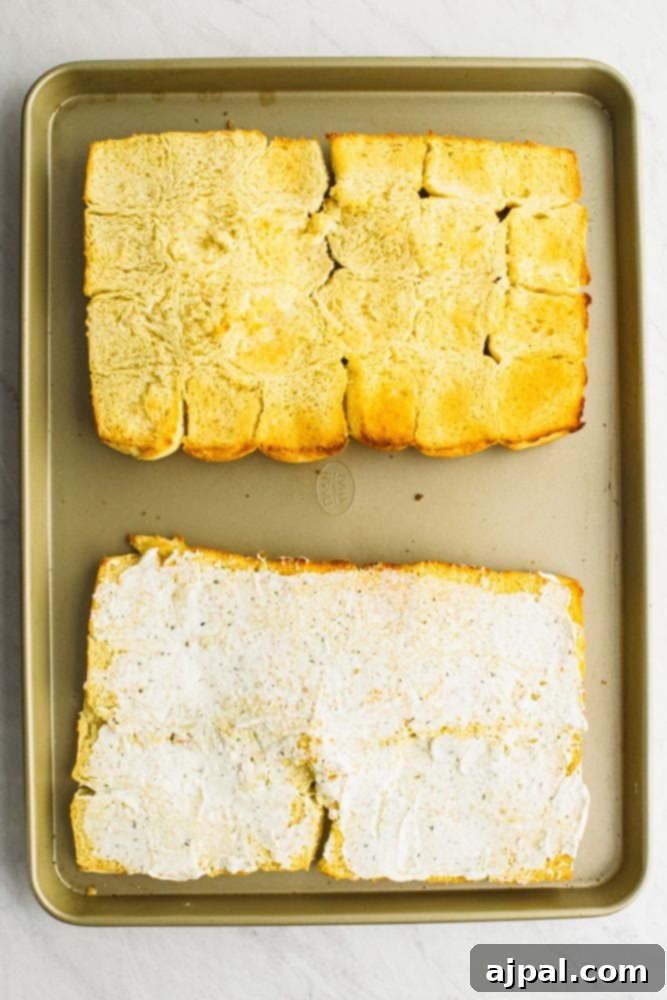 Picture of rolls laid out on a sheet pan, one plain, other with butter on it.