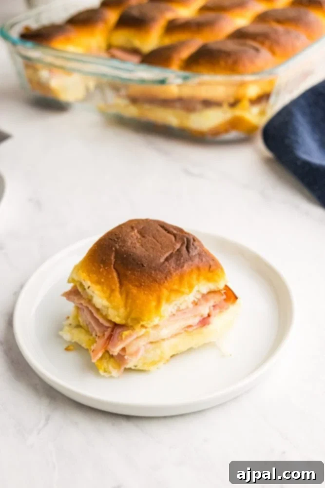 picture of ham and cheese slider on a white plate. 