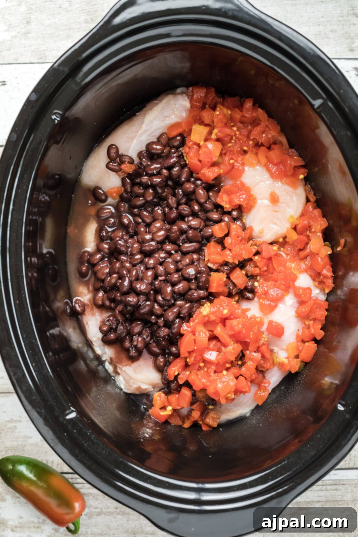 Easy Slow Cooker Chicken Enchilada Soup 10 A slow cooker filled with black beans and peppers, perfect for an easy enchilada soup recipe.