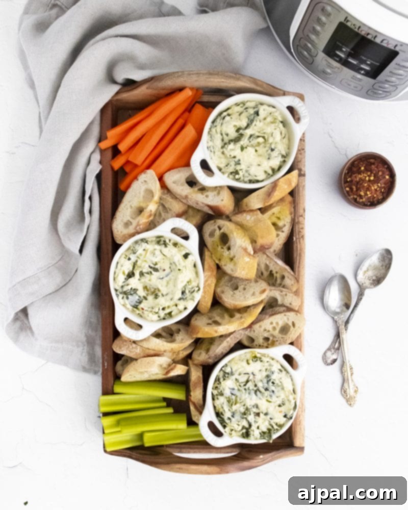Creamy Instant Pot Spinach Dip 14 A festive tray displaying a bowl of Instant Pot spinach dip, elegantly surrounded by crisp carrot sticks and celery, positioned in front of an Instant Pot.