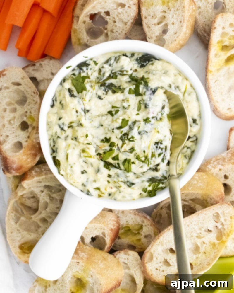 Creamy Instant Pot Spinach Dip 15 A beautifully presented Instant Pot spinach dip with fresh carrots and bread slices arranged around it, ready for a delightful snack or party spread.