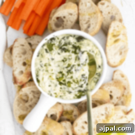 Creamy Instant Pot Spinach Dip 17 A bowl of spinach dip with a spoon next to a piece of bread.