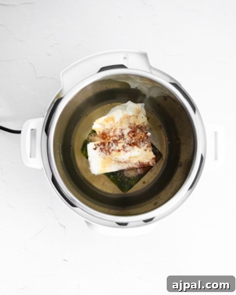 Creamy Instant Pot Spinach Dip 5 Cream cheese and spices in an Instant Pot, beginning the preparation for a creamy spinach dip.