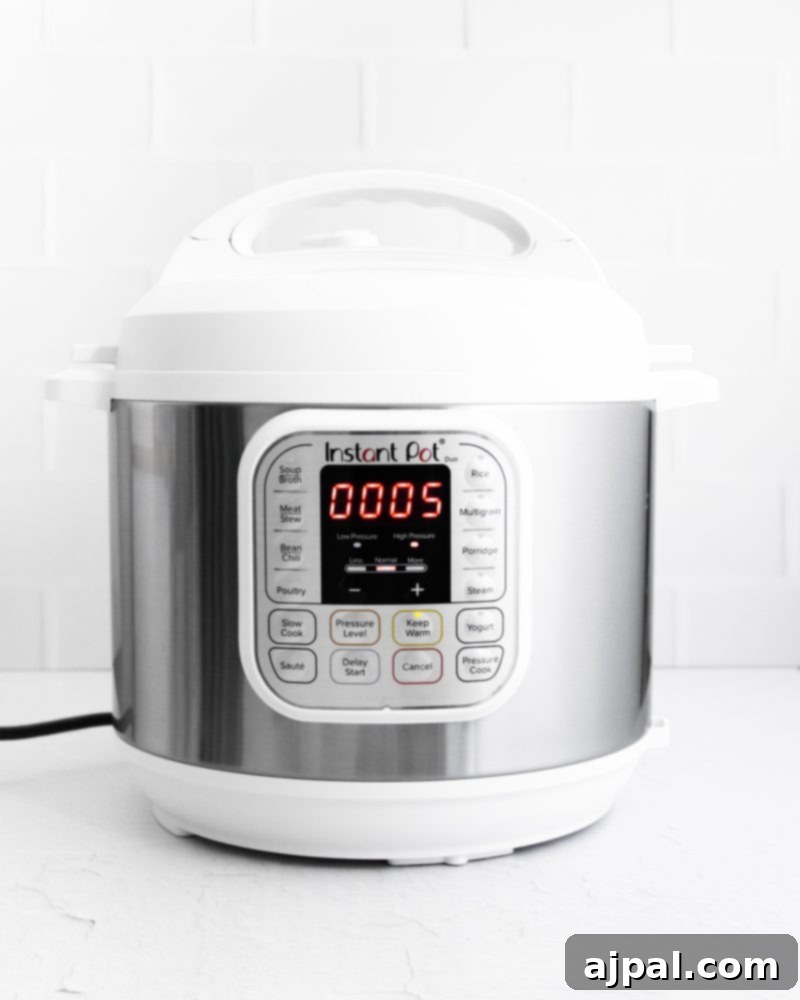 Creamy Instant Pot Spinach Dip 9 An Instant Pot sitting on a white countertop, used for preparing an instant pot spinach dip recipe.