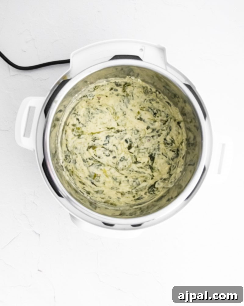 Creamy Instant Pot Spinach Dip 10 A bowl of spinach dip, rich and hot, inside an Instant Pot, ready to be served.