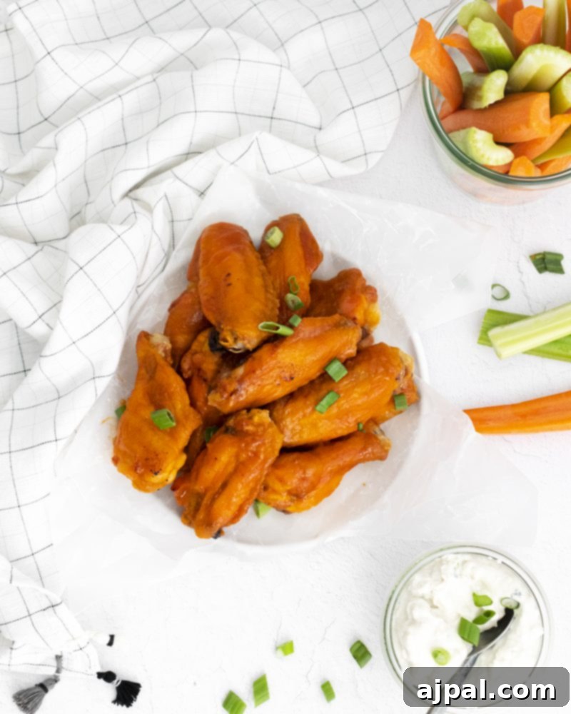 Sticky Sweet Buffalo Wings 4 A vibrant plate of honey buffalo chicken wings served with fresh carrots and celery sticks, ready to be enjoyed.