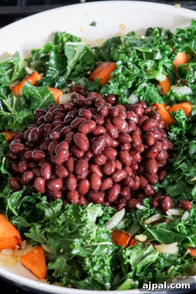The finished sweet potato, kale, and black bean skillet, vibrant and steamy, ready to be served.