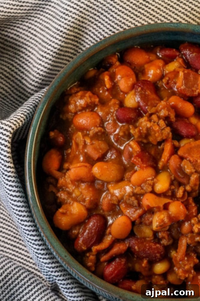 A rich, savory dish of BBQ baked beans generously loaded with beef and bacon, ready to be served.