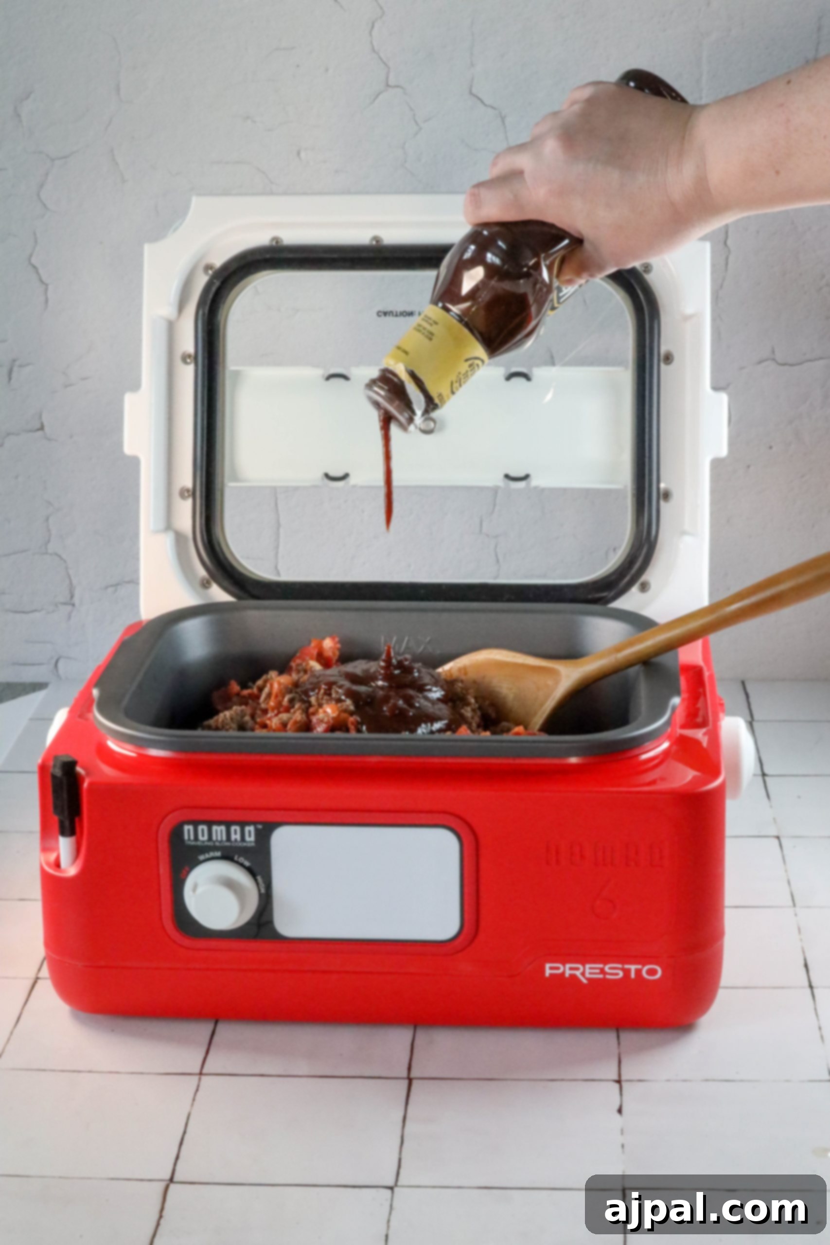 A person effortlessly pours sauce into a red microwave oven while following an easy bean bake recipe.