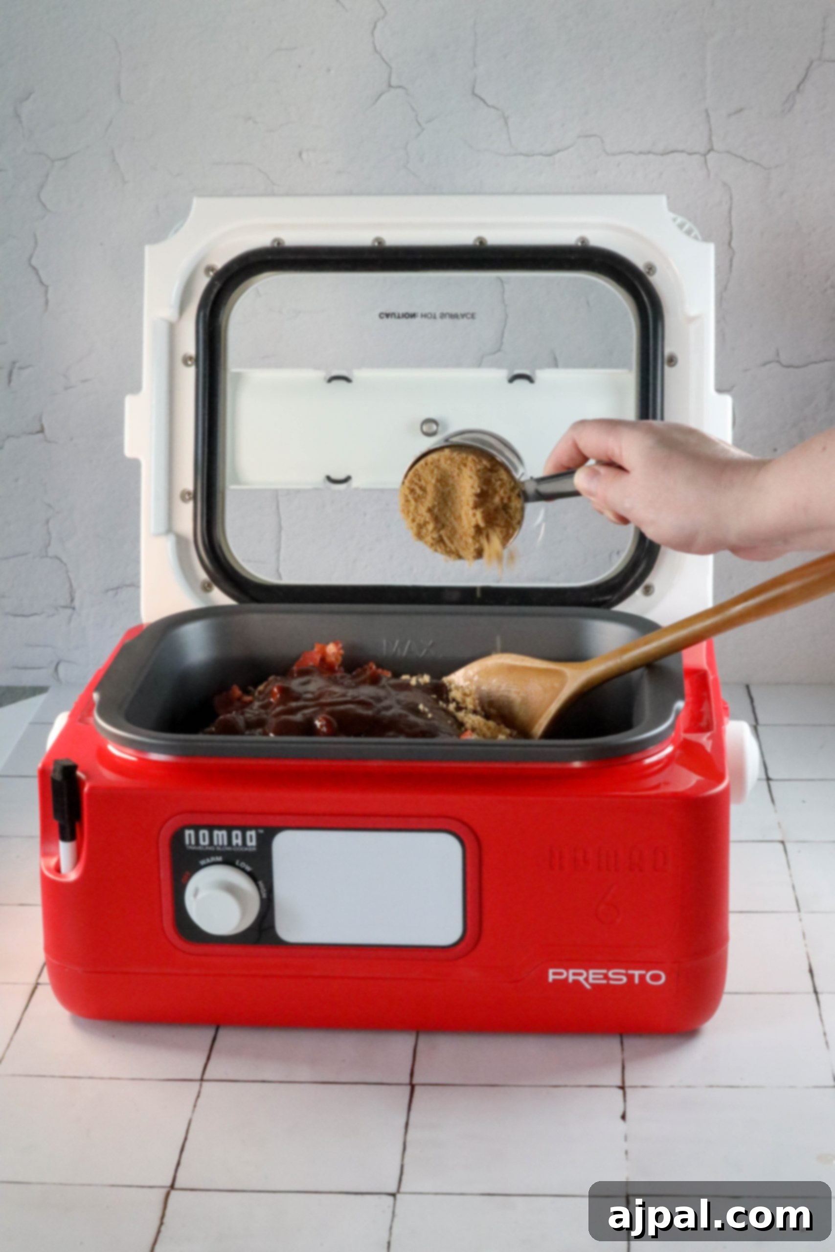 A person is preparing the best ever bean bake recipe in a red microwave oven.
