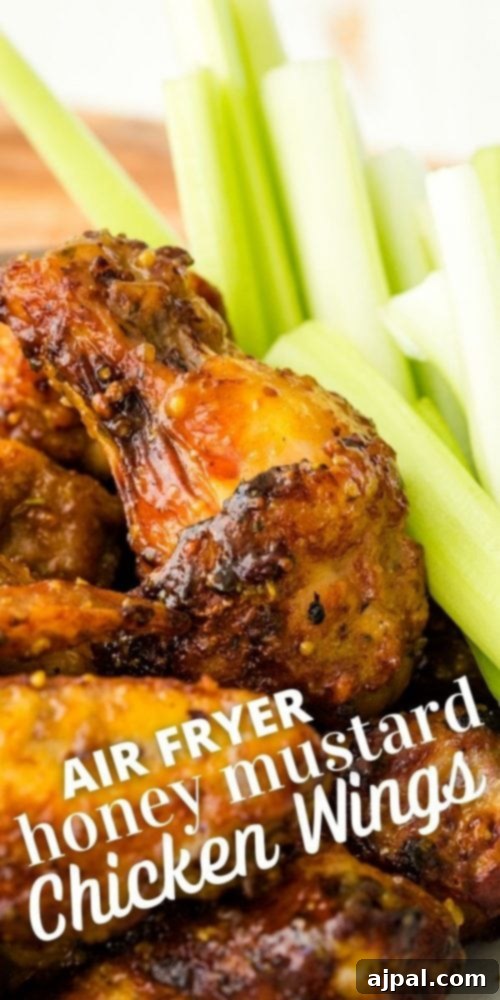 Air Fried Honey Mustard Glazed Wings 11 Sticky honey mustard chicken wings with fresh celery in the background.