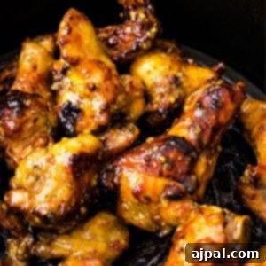 Air Fried Honey Mustard Glazed Wings 12 Air fryer honey mustard chicken wings in a black skillet.