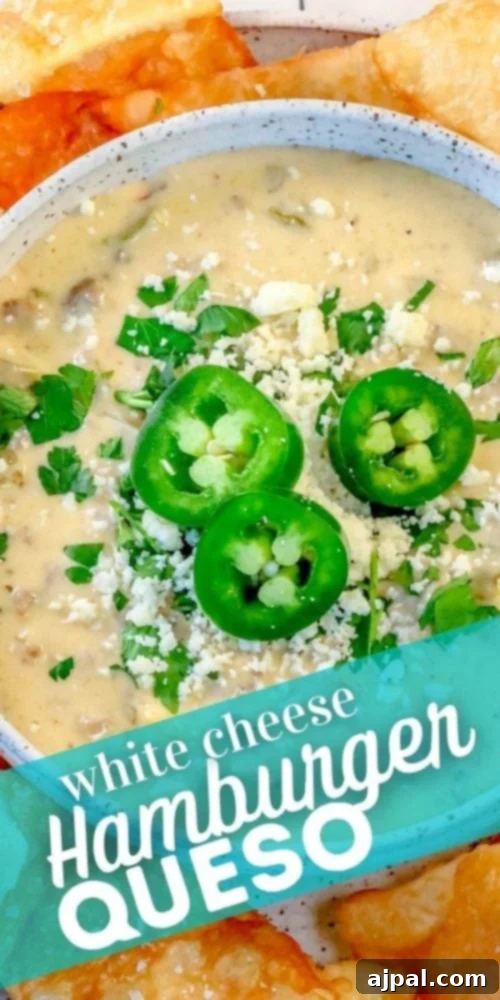 Hamburger White Queso Dip 7 A close-up shot of a bowl of white cheese hamburger queso dip, garnished with fresh cilantro and jalapenos, ready for serving.