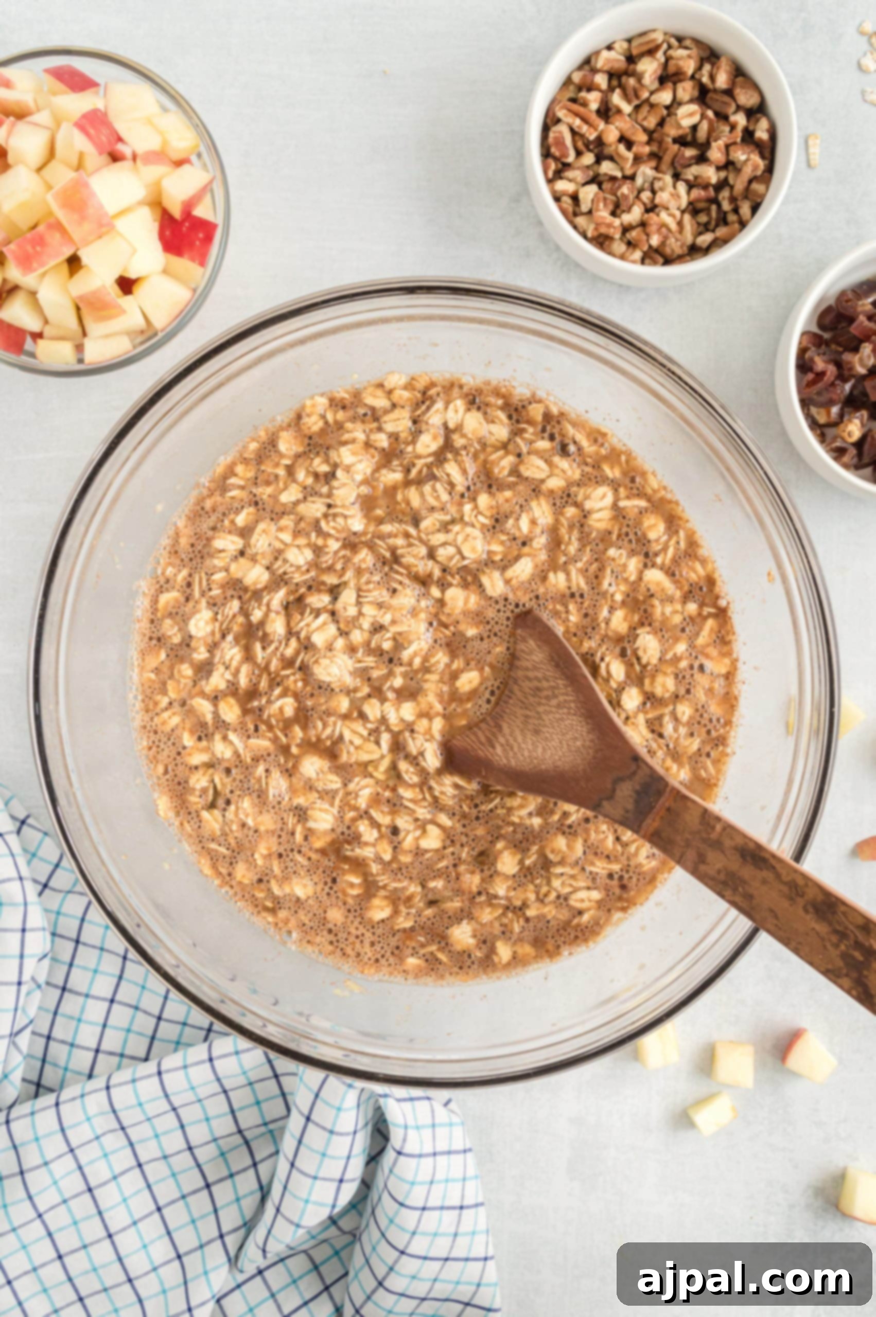 A comforting bowl of baked apple oatmeal, perfectly portioned and ready to be enjoyed with a rustic wooden spoon.