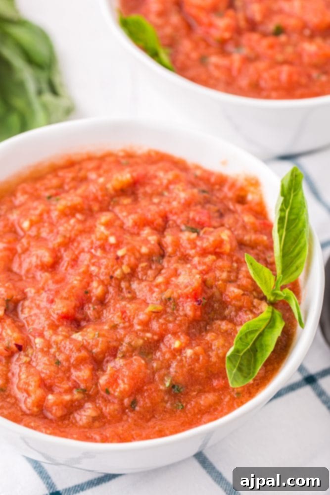 Two bowls of perfectly chilled gazpacho soup on a rustic wooden table, ready to be served.