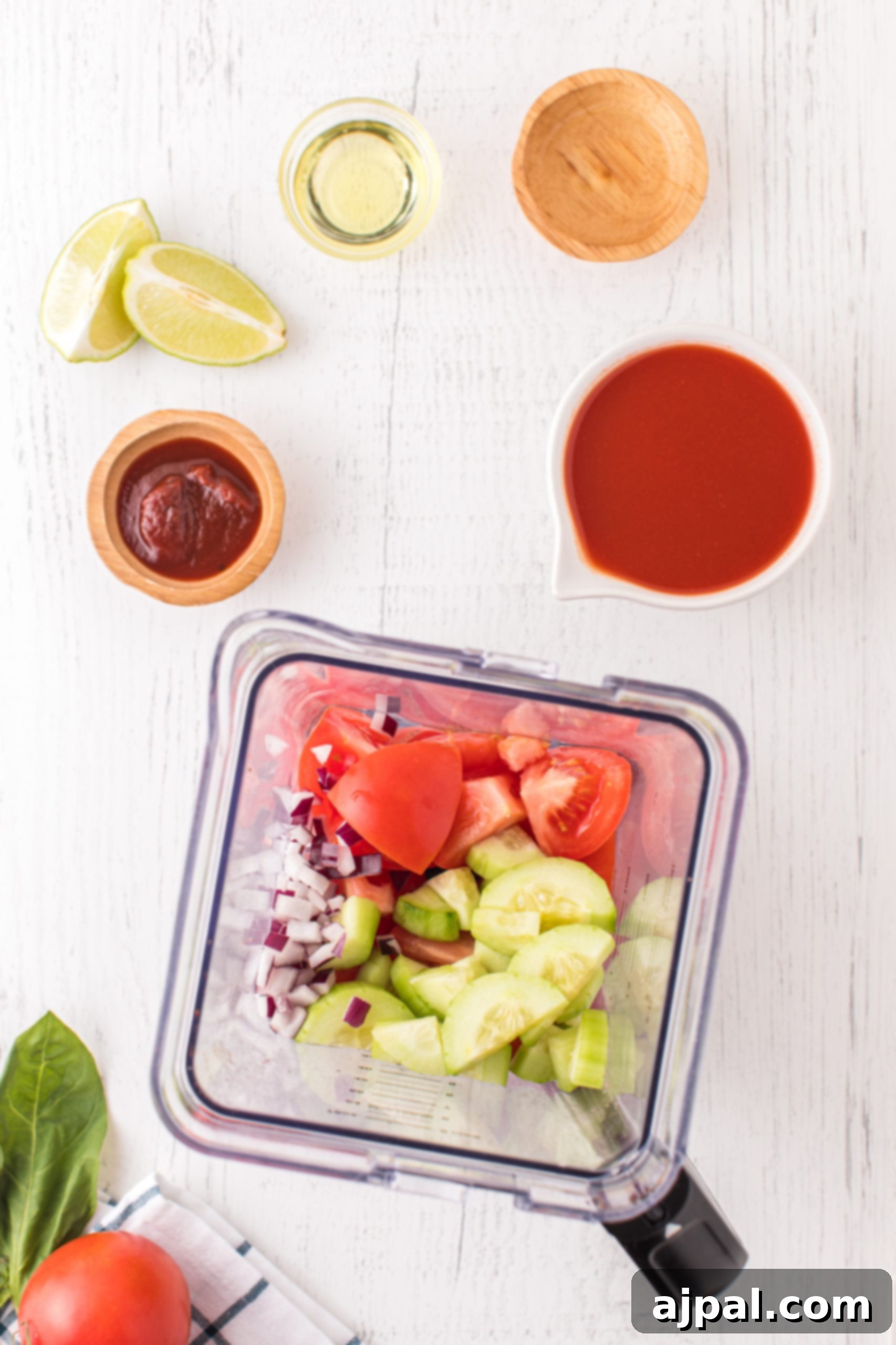 A blender filled with ripe tomatoes, crisp cucumbers, and other fresh ingredients, ready to be blended into gazpacho.