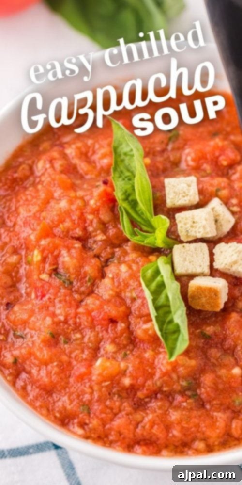 A bowl of easy chilled gazpacho soup with fresh basil garnish, ready to be served.