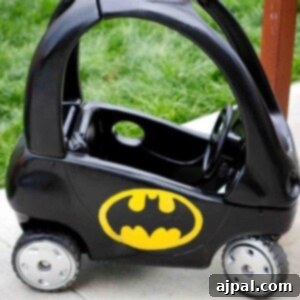 Picture of a Little Tikes Cozy Coupe car expertly painted to look like a Batmobile, showcasing the completed project
