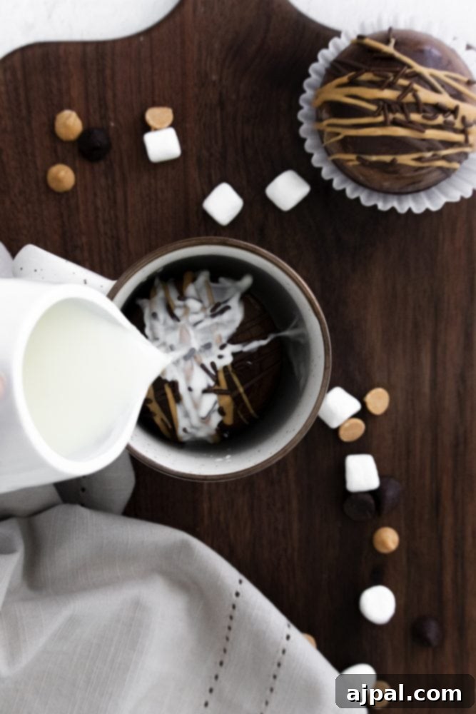 Decadent Peanut Butter Hot Cocoa Bombs 21 Mug with a peanut butter hot chocolate bomb in it, with milk being poured in, illustrating the serving process.