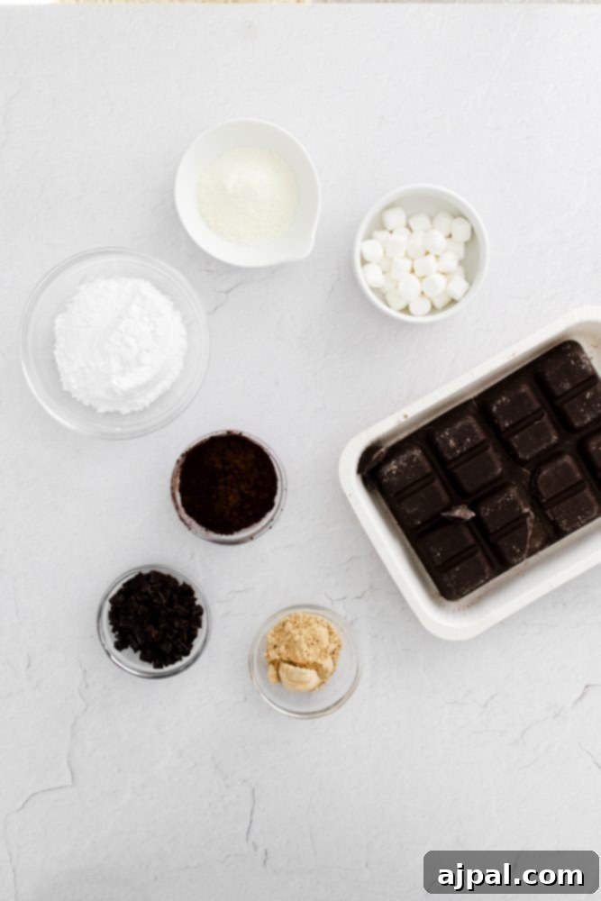 Decadent Peanut Butter Hot Cocoa Bombs 5 Picture of chocolate, marshmallows, sugar, and candy on a table, illustrating hot chocolate bomb ingredients.