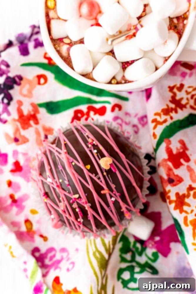 Berry Burst Hot Cocoa Spheres 3 A cup of hot chocolate with marshmallows flavored with a raspberry hot chocolate bomb.