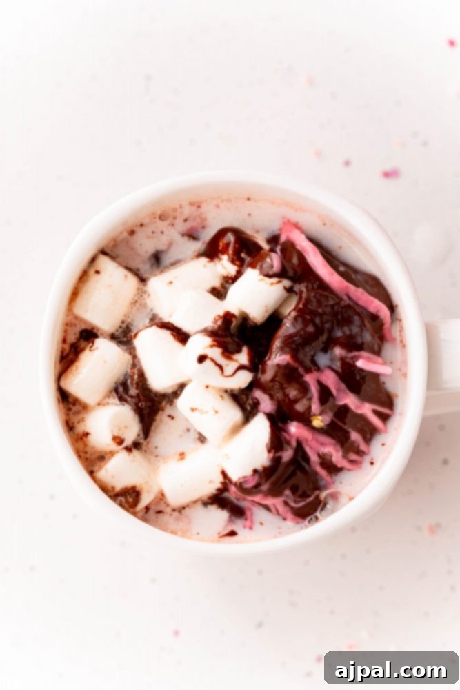 Berry Burst Hot Cocoa Spheres 21 A cup of raspberry hot chocolate with marshmallows and sprinkles, after the bomb has melted.