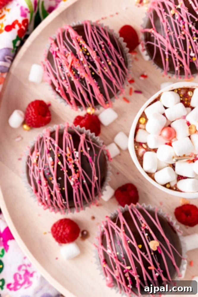 Berry Burst Hot Cocoa Spheres 23 A plate of raspberry hot chocolate bombs with chocolate covered marshmallows and raspberries.