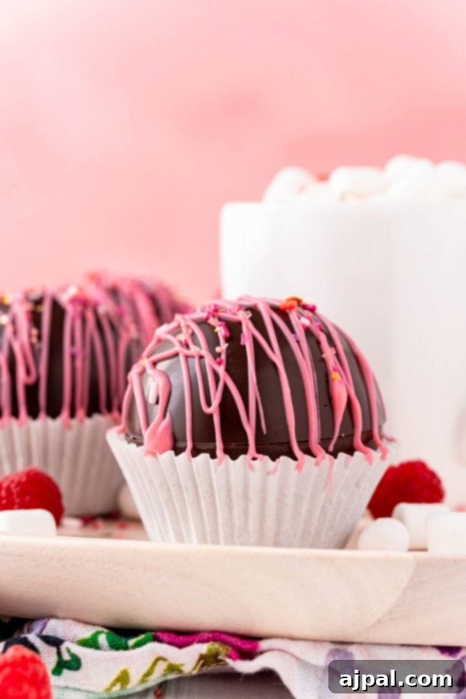 Berry Burst Hot Cocoa Spheres 25 Several chocolate raspberry truffles served alongside a cup of coffee for a sweet treat.
