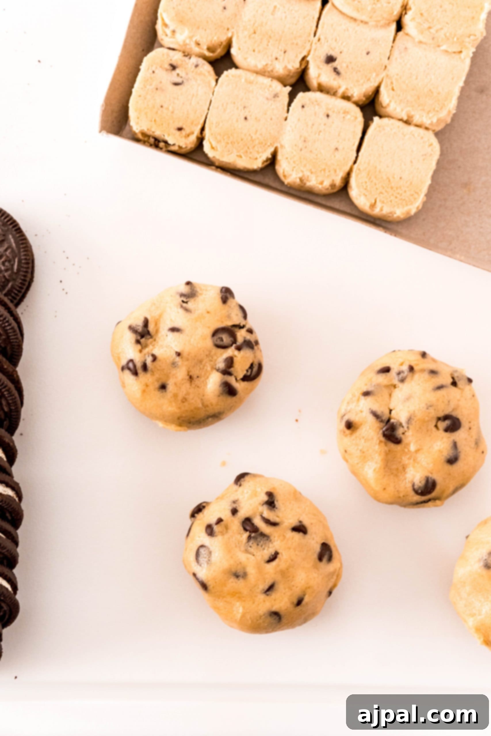 Simple Oreo Stuffed Chocolate Chip Cookies 5 Oreo stuffed cookies on a white plate next to a box of Oreos.