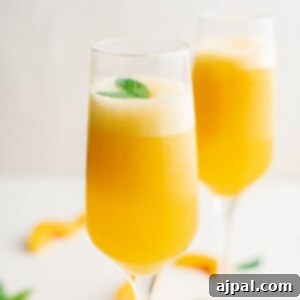 A vibrant peach bellini cocktail, ready to be served and enjoyed.