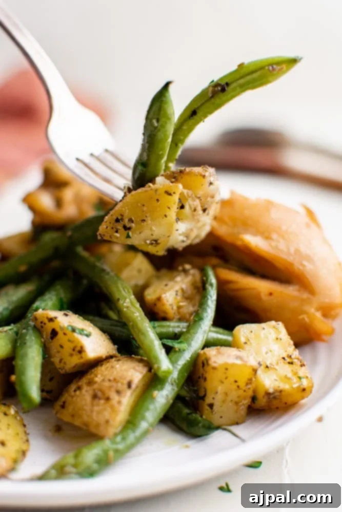 Savory Herb Roasted Green Beans and Potatoes 4 roasted potatoes and green beans on a fork