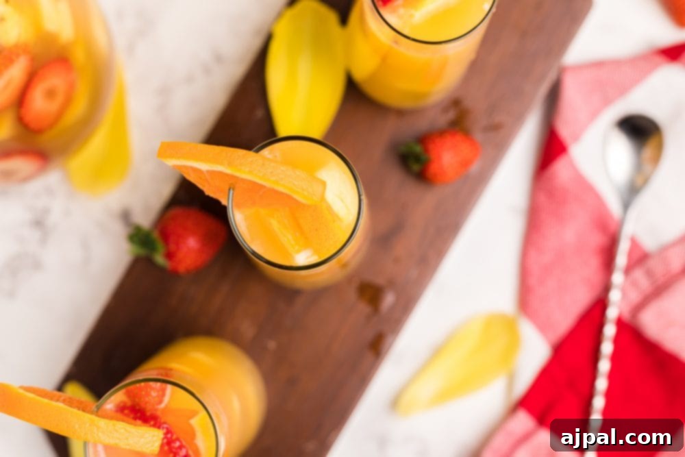 orange drinks in tall glasses with fruit in them from above