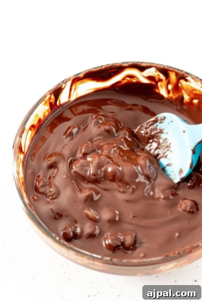 Irresistible Mint Hot Chocolate Bombs 5 clumpy chocolate in a bowl being stirred