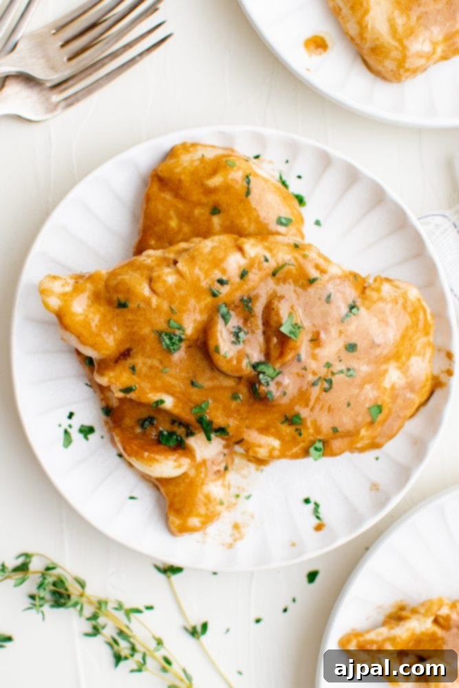 Creamy Garlic Chicken Made Simple 2 Chicken in a creamy sauce with parsley on it, garnished and ready to serve