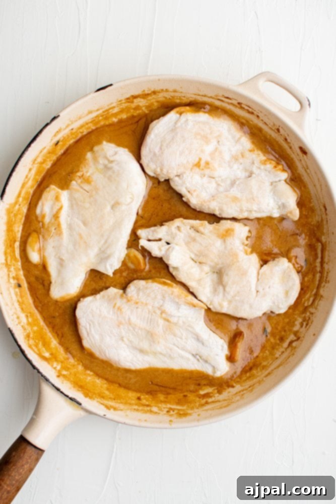Creamy Garlic Chicken Made Simple 11 A skillet filled with creamy garlic chicken in a curry sauce.