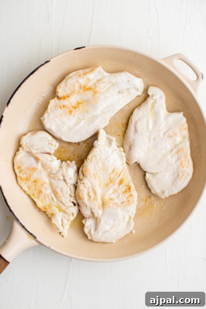 Creamy Garlic Chicken Made Simple 6 Skillet chicken with creamy garlic sauce on white background.