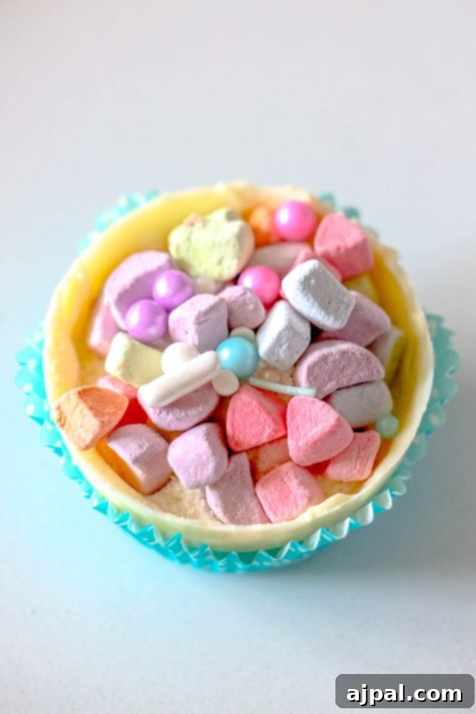 Magical White Chocolate Lucky Charms Bombs 4 half of a white cocoa bomb being filled with lucky charms marshmallows and sprinkles
