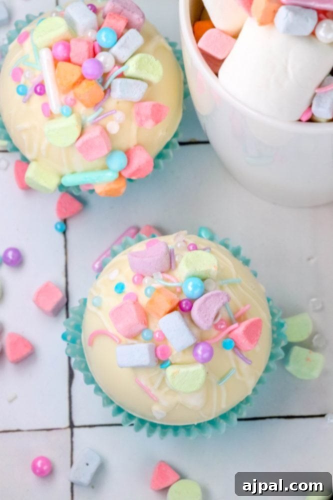 Magical White Chocolate Lucky Charms Bombs 5 white chocolate hot chocolate bomb in a blue cupcake wrapper with lucky charms marshmallows and sprinkles on top next to a mug with cocoa, sprinkles, and marshmallows in it