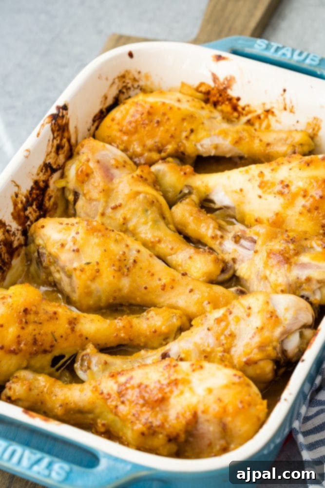 Glazed Honey Mustard Chicken Drumsticks 3 Baked honey mustard chicken drumsticks in a blue baking dish, golden brown and glazed.