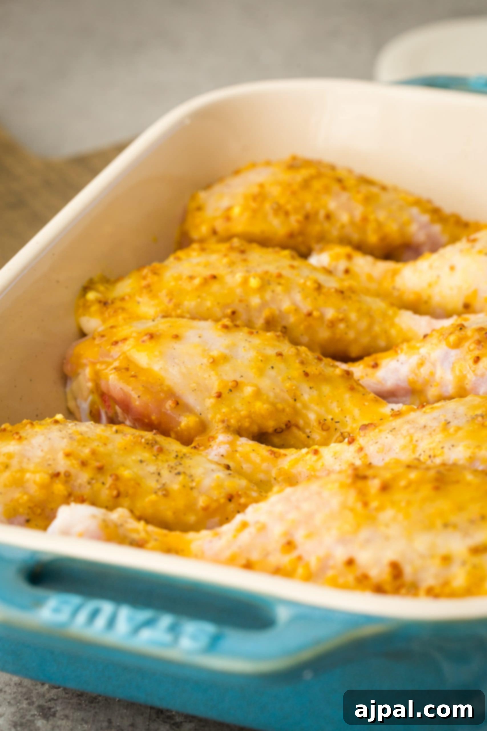 Glazed Honey Mustard Chicken Drumsticks 8 Honey mustard chicken drumsticks in a blue baking dish.