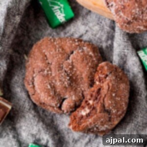 A double chocolate mint cookie with a bite taken out of it.