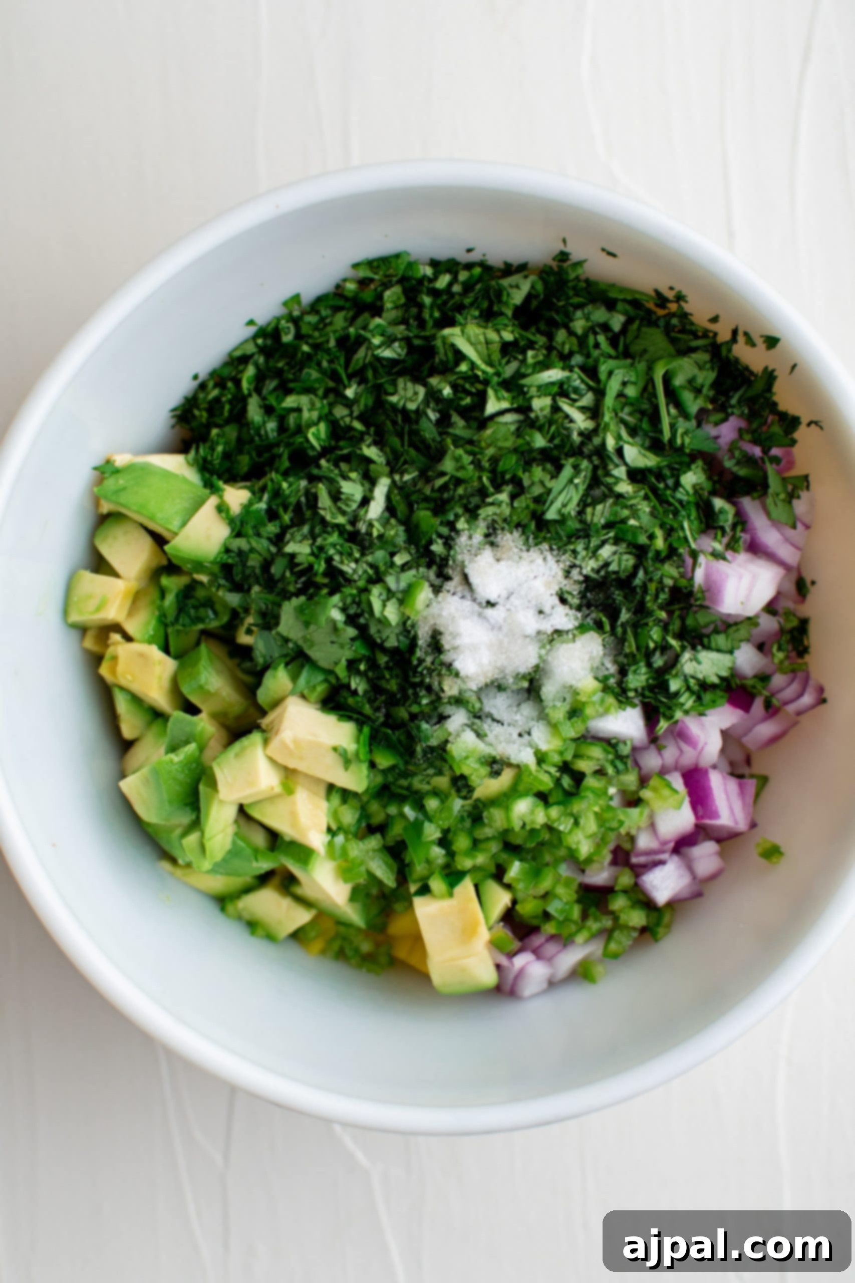 Tropical Mango Avocado Salsa 7 A white bowl with avocado and cilantro.