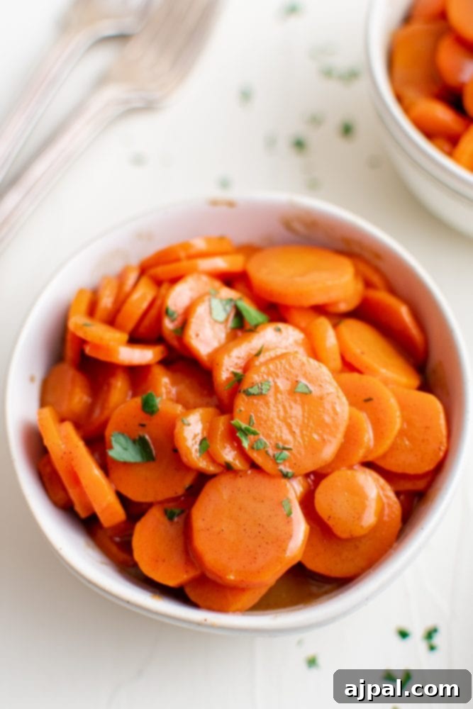 Picture of glistening glazed carrots in a elegant white serving bowl, ready to be enjoyed.