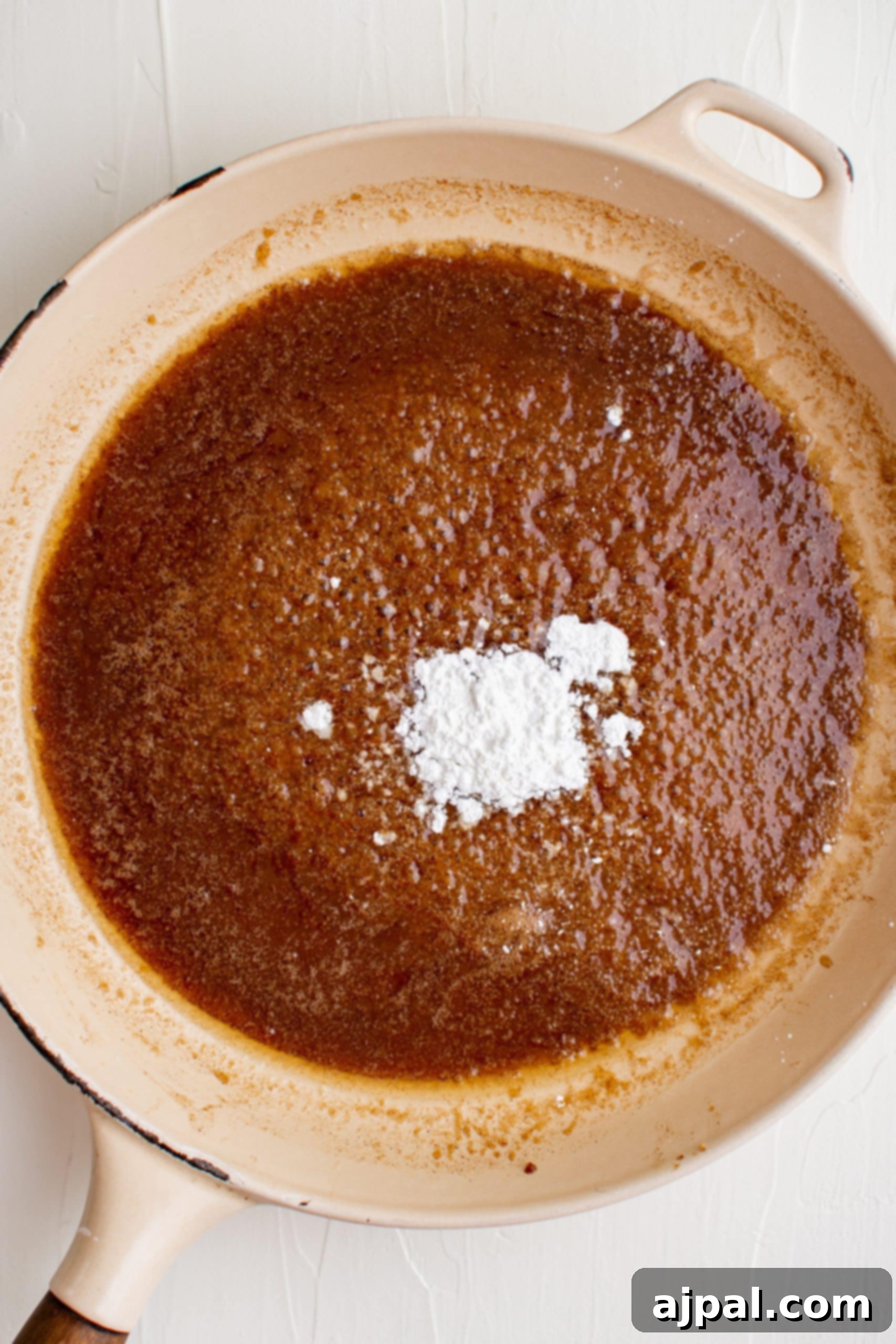 A skillet filled with brown sugar and powdered sugar-glazed carrots.